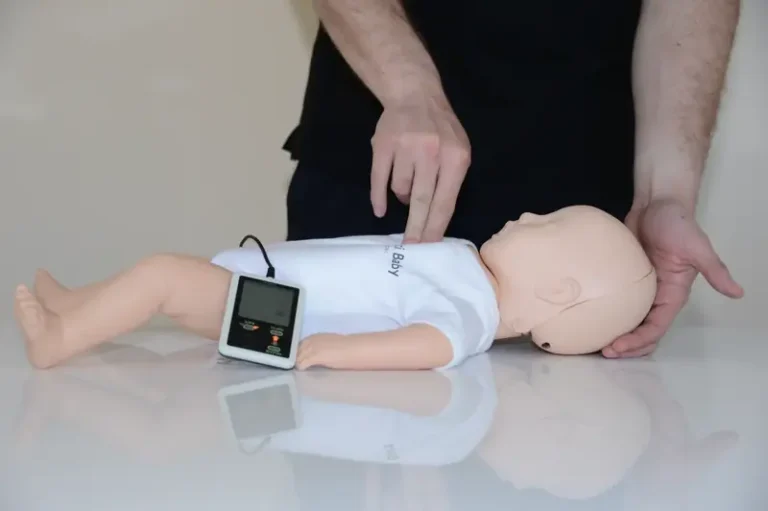 Participant pratiquant une réanimation cardio-pulmonaire sur un mannequin nourrisson pendant un recyclage MAC SST à Lyon.
