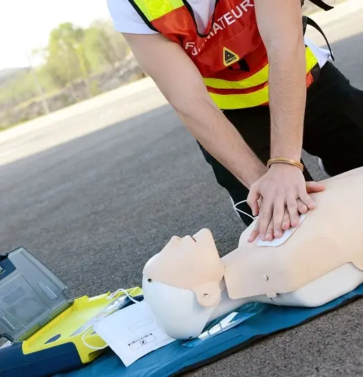 Formateur réalisant des compressions thoraciques sur mannequin lors d’une formation SST à Lyon